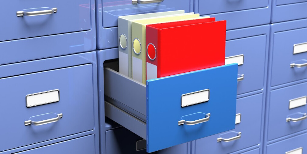Armários de arquivos com uma gaveta aberta cheia de pastas de arquivos.